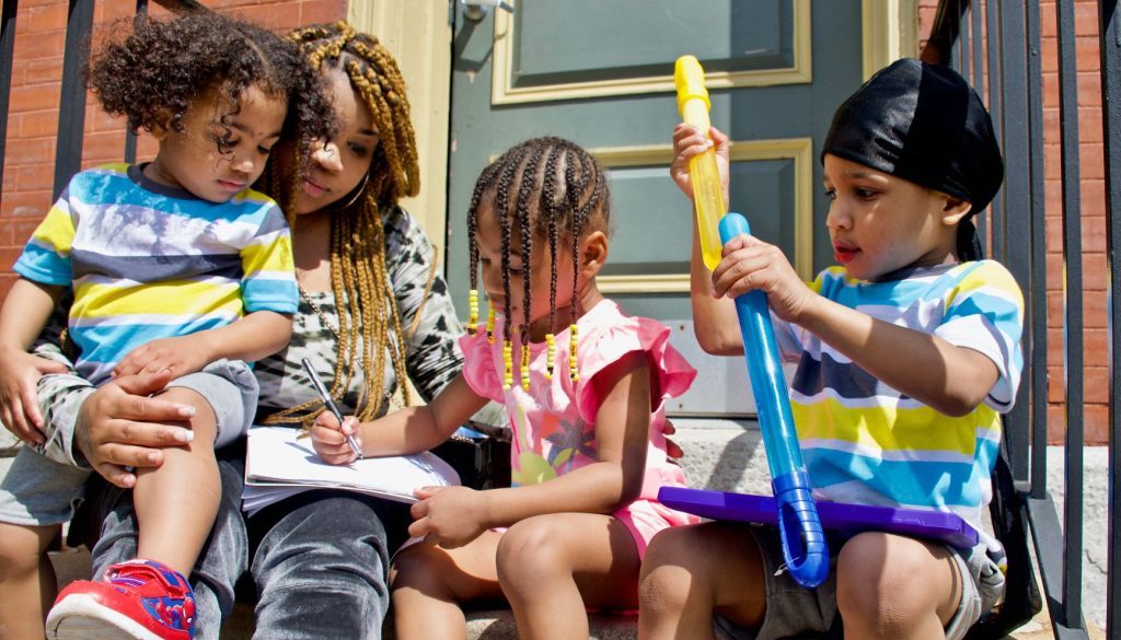 Courtnesha with all kids on porch - one with toy.smaller